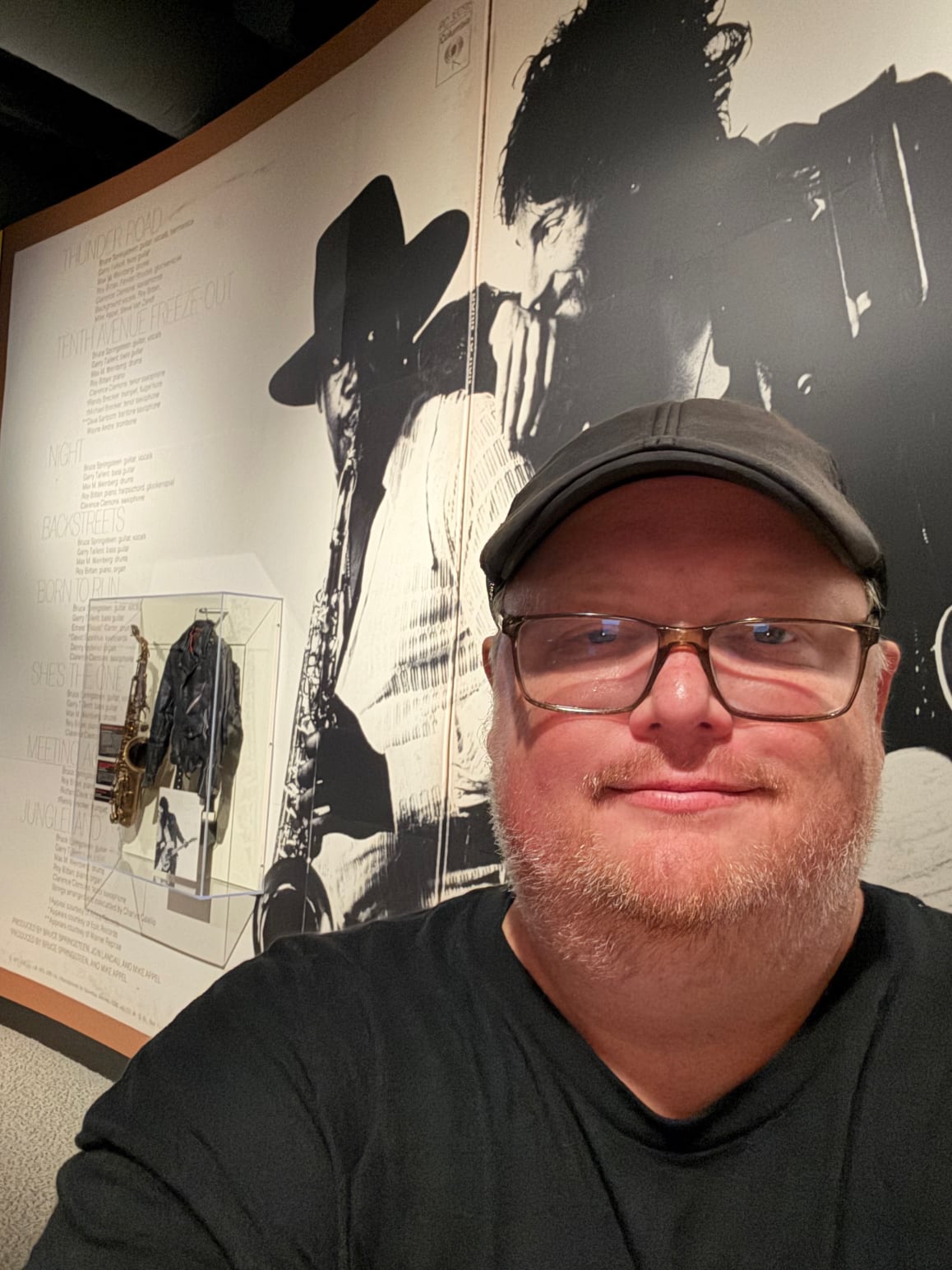 Mark Dauner in front of a Bruce Springsteen and Clarence Clemons exhibit at the Rock and Roll Hall of Fame.